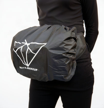 Tailored all-weather rain cover for the Moth Pro bag, worn at the waist, Moth Makeup branding visible