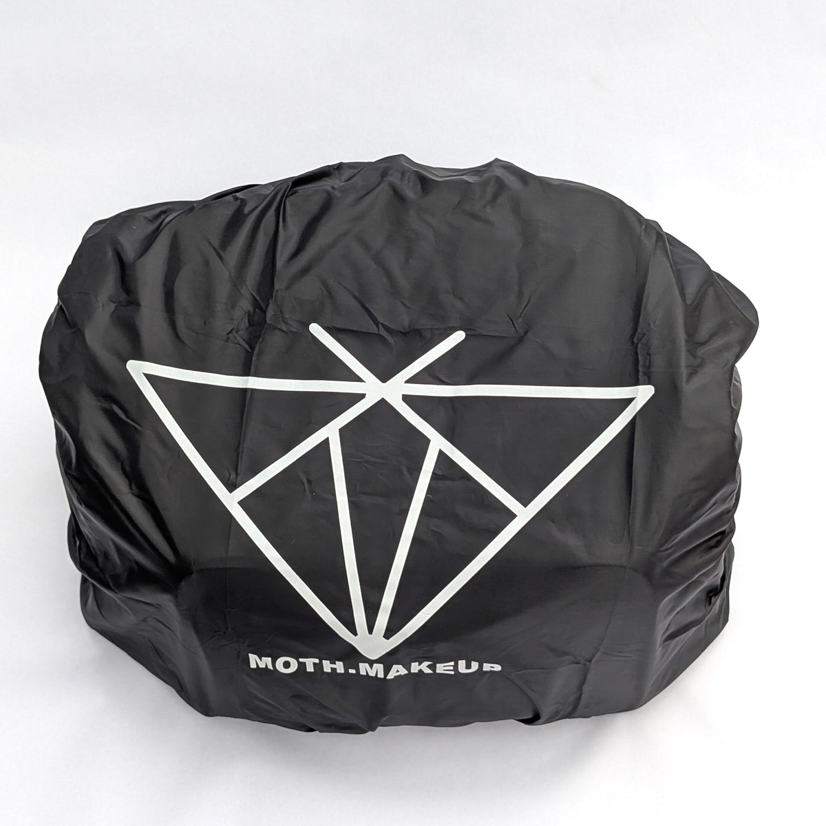 Rain cover fitted over the Moth Pro bag, angled view showing the elastic gathered edge at the base