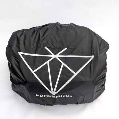 Rain cover fitted over the Moth Pro bag, angled view showing the elastic gathered edge at the base