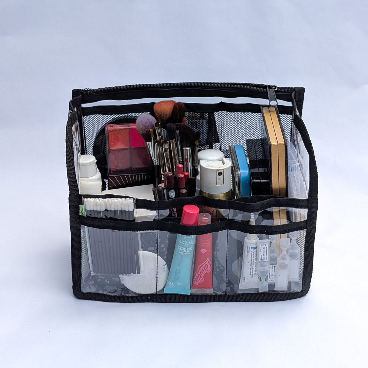 PVC insert for Moth Pro bag, front view, filled with makeup palettes, brushes and tubes