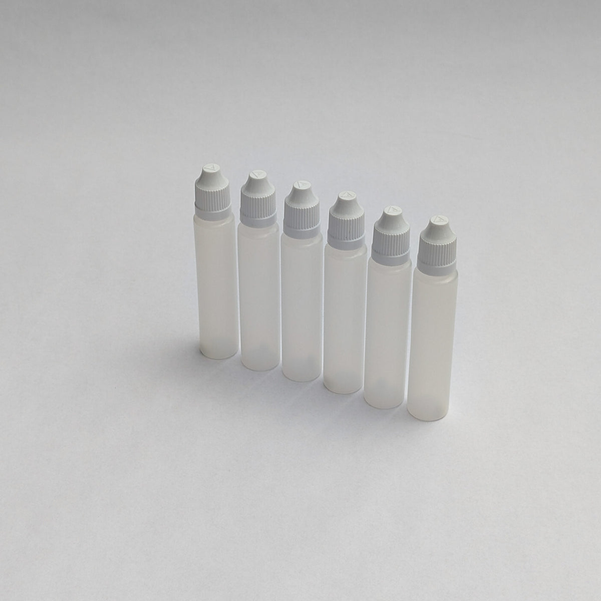 Six long dropper bottles standing in a row, translucent with grey screw caps