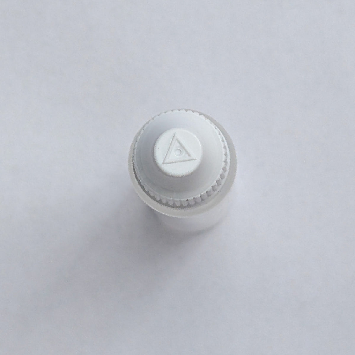 Long dropper bottle cap close-up from above, showing the embossed logo detail