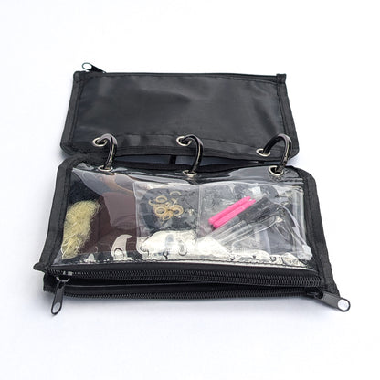A black zippered ring-binder style pouch shown open on a white background, with clear front pockets containing small accessories and tools.
