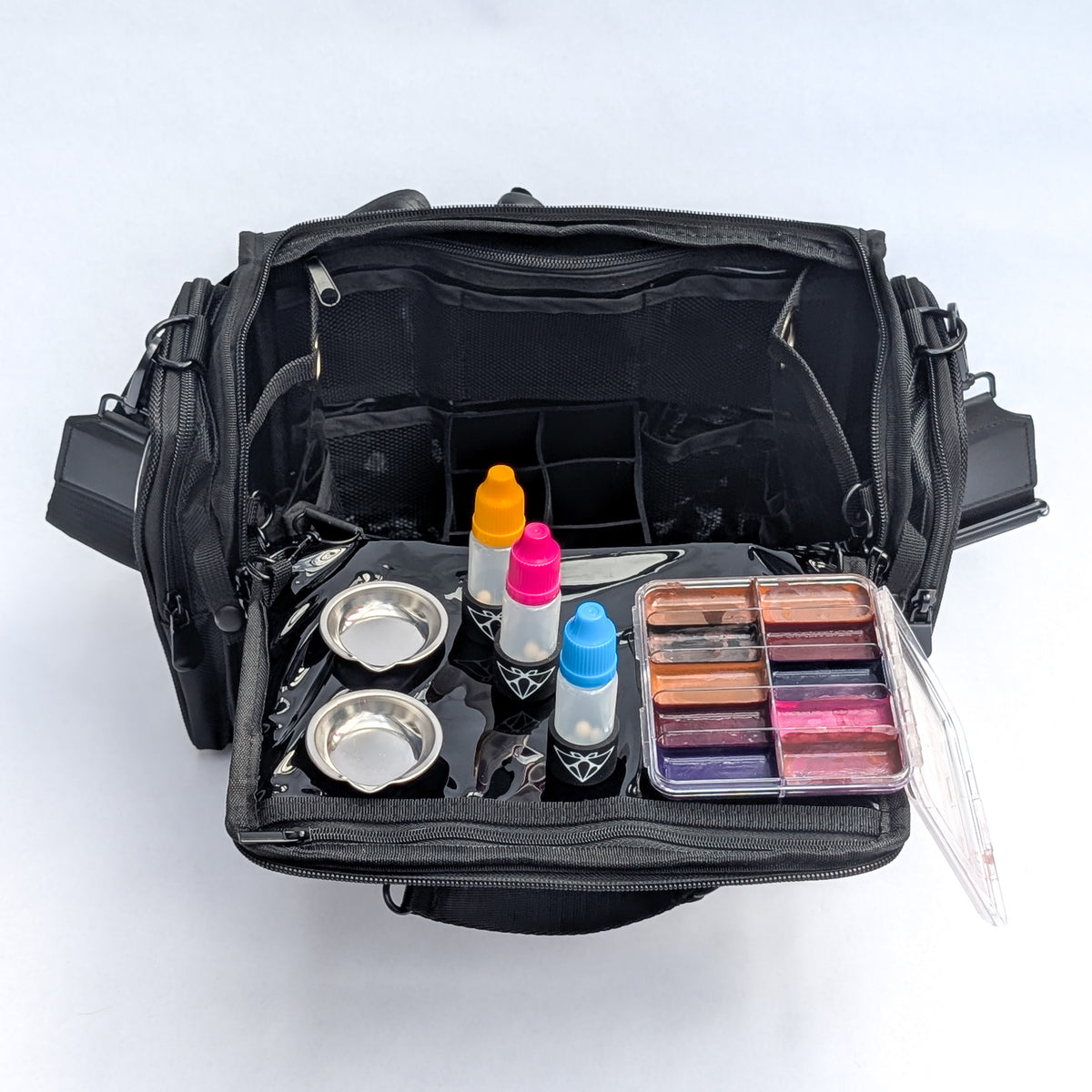 Moth Pro set bag open from above, magnetised tray extended with decant bottles, mixing bowls and a palette